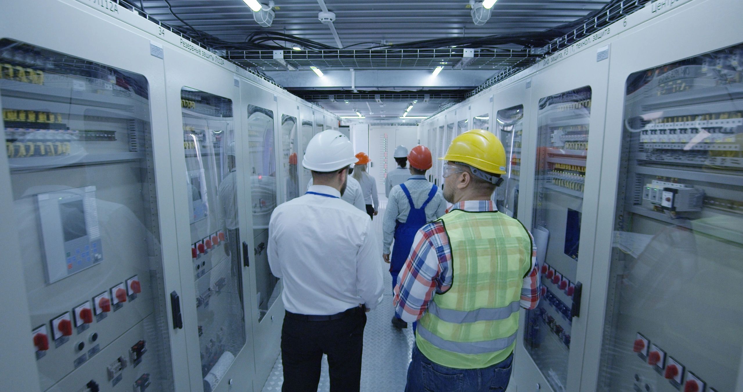 Electrical workers walking in the control room